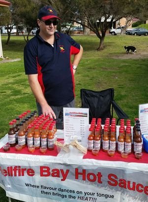 Ernest behind a table full of sauces at the Esperance Village Markets